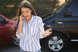 distressed woman talking on phone after auto wreck