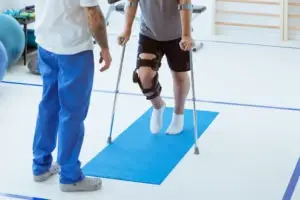 person wearing knee brace and using crutches