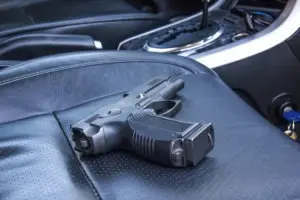 a gun in the passenger seat of a car