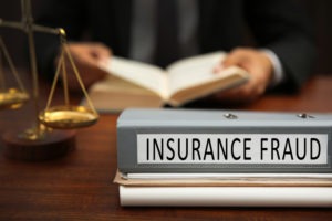 a binder labeled insurance fraud on the desk of a lawyer