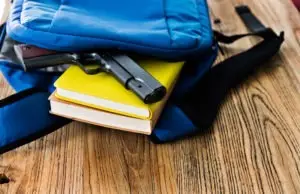a gun sticking out of a backpack