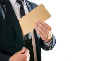 businessman pockets envelope with money