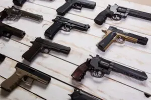 handguns and firearms on wooden backdrop