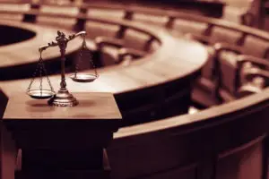 scales of justice in empty courtroom
