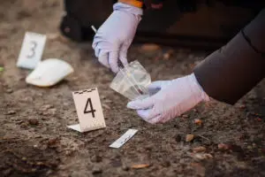 A law enforcement officer collects evidence at a crime scene. A Los Angeles criminal defense lawyer can build your case using direct and circumstantial evidence.