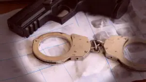 evidence gun next to fingerprints and handcuffs
