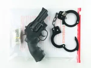 handcuffs revolver and money atop evidence bag