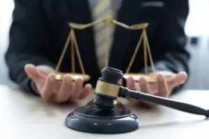lawyer balancing scales of justice with gavel in foreground