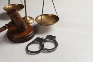 scales behind gavel and handcuffs