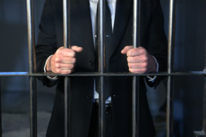 businessman behind bars