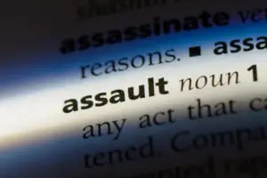 closeup of word assault in dictionary