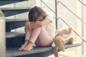 sad little girl sitting on stairs
