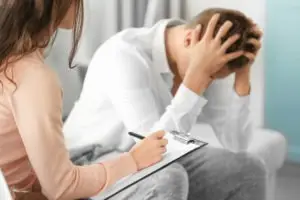 depressed man talking to female therapist