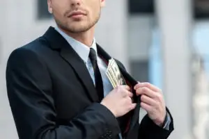 man in suit pocketing money