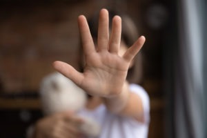 little girl holding a hand up in defense