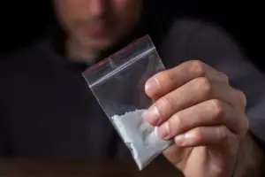 man holding powdered drugs