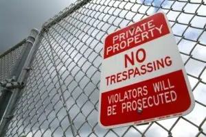 trespassing sign on a chain fence