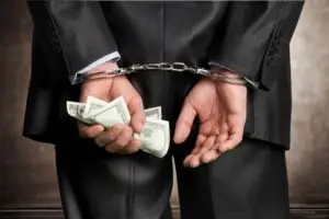businessman in cuffs holding money
