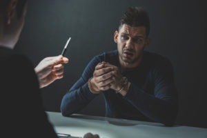 man in handcuffs being interviewed