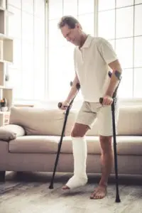man with broken leg using crutches