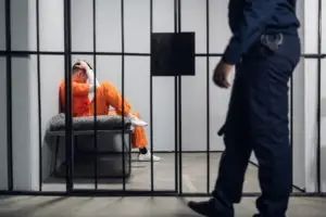 prison guard passing man in a cell