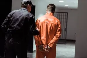prison officer leading criminal to jail cell