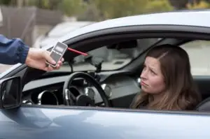 female driver being asked to take a breathalyzer