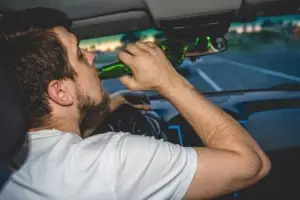 man drinking beer while driving