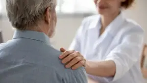 female doctor comforting an older man