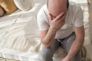 sad man sitting on a bed