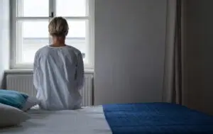 sad woman sitting on a bed
