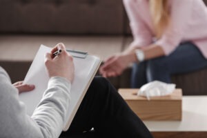 therapist taking notes while with a patient