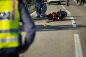 crashed motorcycle with road workers