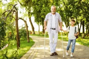 older man on crutches with grandson