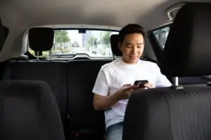 Asian man in the back of a rideshare car