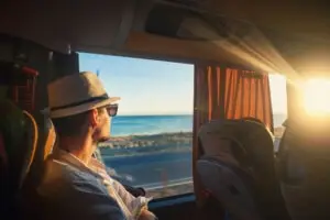 man traveling looking through bus window