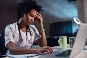 stressed black nurse on computer