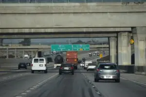 Truck drives on I-105 freeway next to small cars.