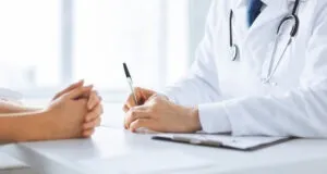 doctor taking notes with patient