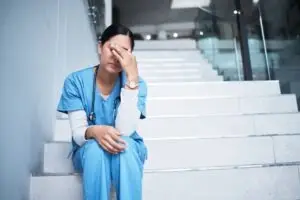 nurse sitting stressed on stairs