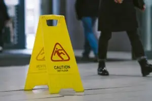 people walking past wet floor sign