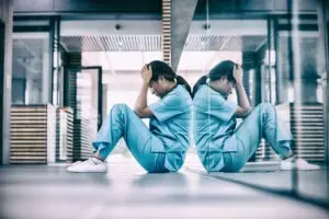 stressed nurse sitting on floor