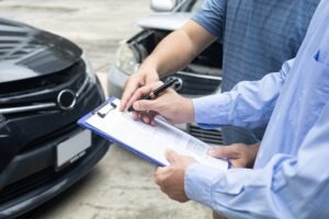 Two people fill out an SR-1 report after a car accident.