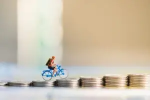 A bicycle toy rides up coins. What’s the average bicycle injury settlement in California?