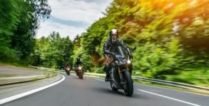 Group of people riding motorcycles on the road.