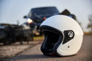 A motorcycle helmet rests on the road after a crash. Call a Hawthorne motorcycle accident lawyer now.