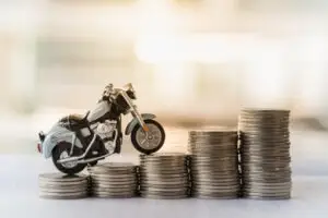 A toy motorcycle balances on coins. What’s the average motorcycle accident settlement in California?