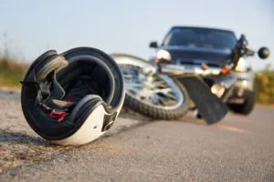a motorcycle and helmet lying on the road in front of a pickup truck