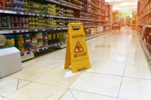 a supermarket aisle with a yellow wet floor sign