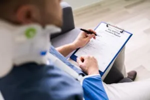 a man in a neck brace filling out a slip and fall accident report